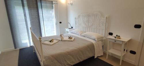 a bedroom with a white bed with two towels on it at My Holiday - Alessandra Residence - Domaso in Domaso