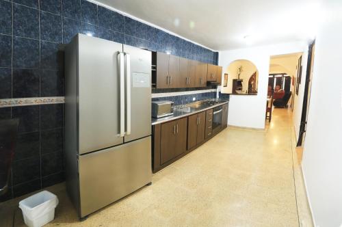 a kitchen with a stainless steel refrigerator and brown cabinets at Familiar y acogedor in Medellín