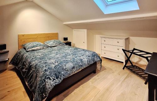 ein Schlafzimmer mit einem Bett und einer Kommode in der Unterkunft Maison "Le Figuier" TREVOUX climatisée in Trévoux