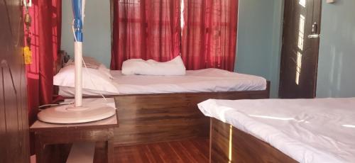 Zimmer mit 2 Betten und einer Lampe auf einem Tisch in der Unterkunft Kantipur community homestay in Chitwan