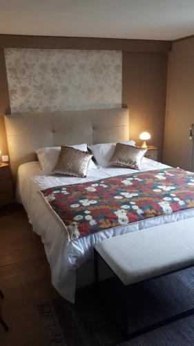 a bedroom with a large bed with a floral quilt at Chambre d'hôtes Les Hortensias in Gelos
