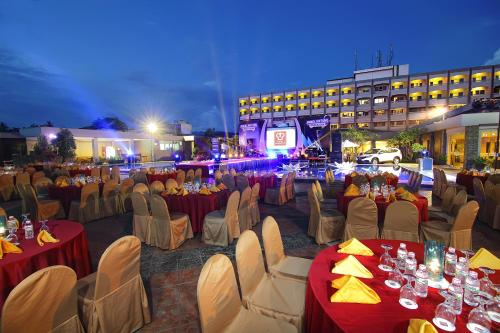 a group of tables and chairs with people sitting at at Pangeran Beach Hotel in Padang