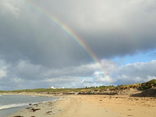 a rainbow on a beach with the ocean at Elm Tree Motel in Warrnambool