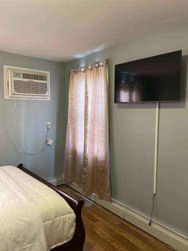 a bedroom with a bed and a television on the wall at Haus Serenity in Hollis