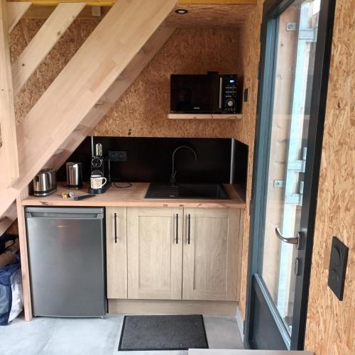 une cuisine avec un évier et un micro-ondes dans l'établissement la clef des champs, à Ryes