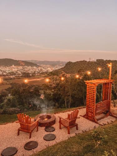 two chairs and a fire pit on a hill at Cabana Lua Crescente Ituporanga in Ituporanga