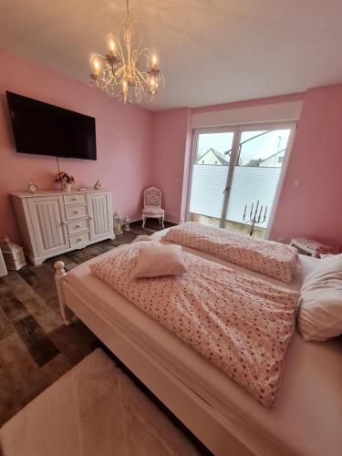 a bedroom with a large bed and a chandelier at Premium Apartment in Sehnde