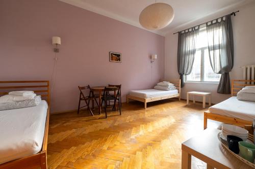a room with two beds and a table and chairs at Trzy Kafki Private Rooms in Kraków