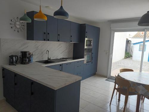 ラ・コティニエールにあるiledoのキッチン(青いキャビネット、テーブル付)、ダイニングルーム