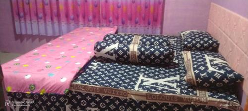 a group of pillows sitting on top of a bed at D' pamor Homestay in Halangan