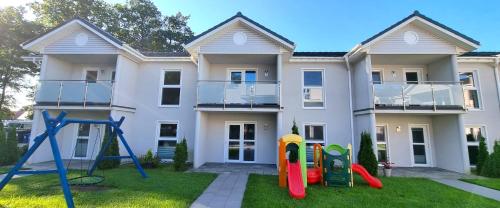 a house with a playground in front of it at Srebrna Wydma Resort in Dąbki