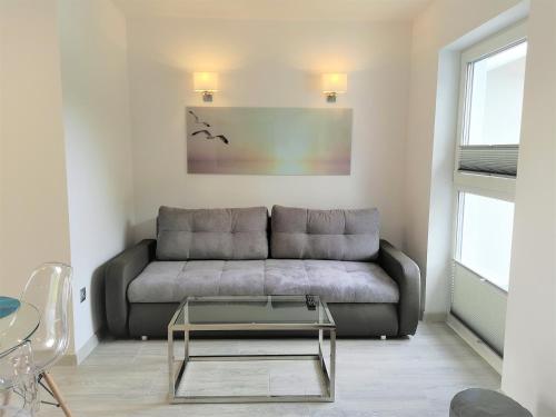 a living room with a couch and a glass table at Srebrna Wydma Resort in Dąbki