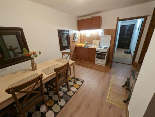 a kitchen with a table and chairs in a room at Kojadinovica Koliba in Mokra Gora