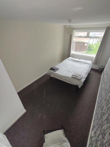 um quarto vazio com duas camas e uma janela em Homestay near a station and park em Longbridge