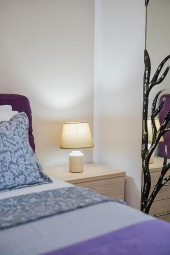 a bedroom with a bed with a lamp on a night stand at Luisa Holiday Home in Ádhele