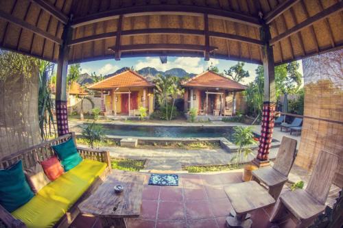 an outdoor living room with a bench and a table at Global Royal Pemuteran in Pemuteran