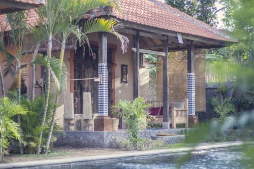 a house with a porch and a pool in front of it at Global Royal Pemuteran in Pemuteran