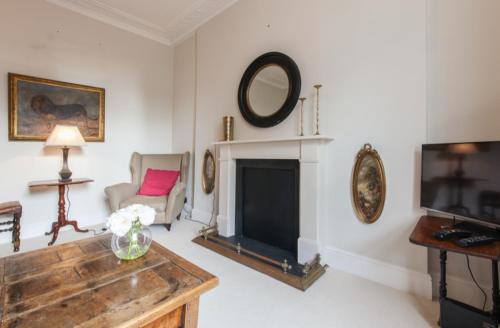 a living room with a fireplace and a tv at Charming Apartment in Chelsea in London