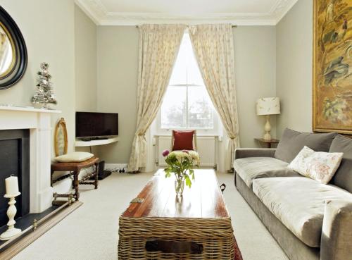 a living room with a couch and a table at Charming Apartment in Chelsea in London