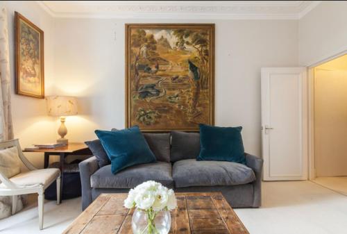 a living room with a couch and a table at Charming Apartment in Chelsea in London