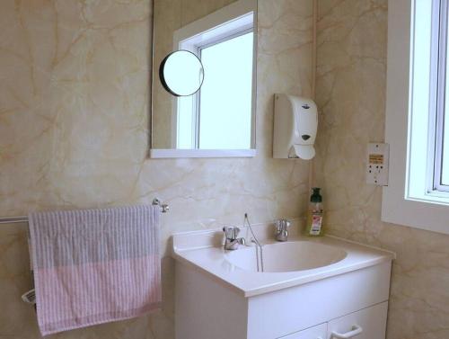 a bathroom with a sink and a mirror at Pohara's Seaside Chalet in Pohara