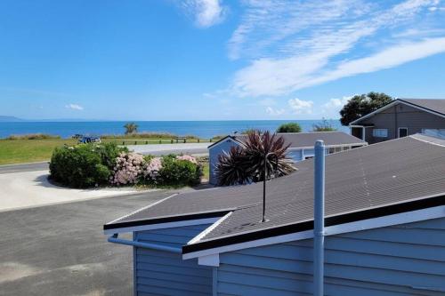 a roof of a house with the ocean in the background at Pohara's Seaside Chalet in Pohara