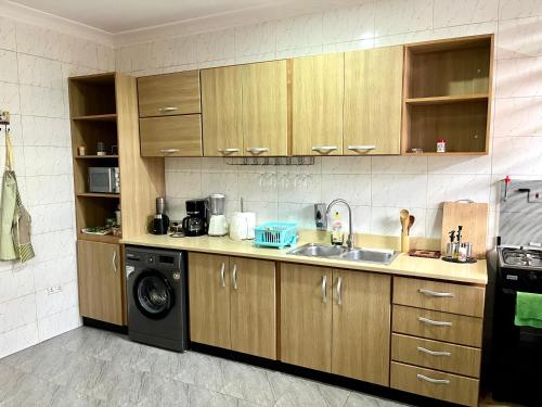 een keuken met een wastafel en een wasmachine bij Hidden Gem In Oyibi New 2 Luxury Bedroom Apartment in Aburi