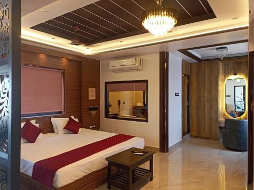 a hotel room with a large bed and a chandelier at Ivy Nirvana in Kiul