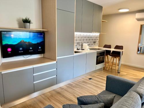 a living room with a tv and a kitchen at RIACENTRUM - Smart Residence in Aveiro