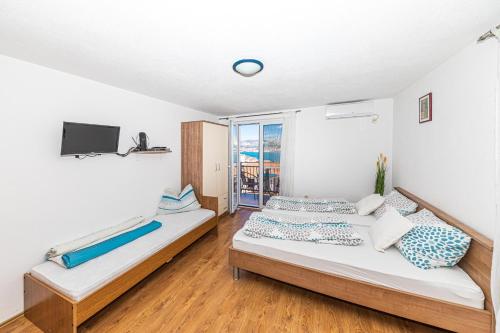 sypialnia z dwoma łóżkami i telewizorem w obiekcie Apartman Simic w Trogirze