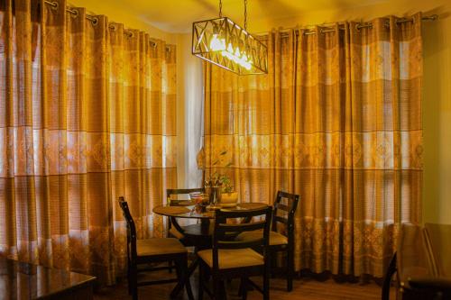 Suku family house. في باتان: غرفة طعام مع طاولة وكراسي وستائر