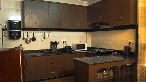 a kitchen with wooden cabinets and a counter top at Suku family house. in Pātan