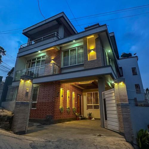 a brick house with a garage at night at Suku family house. in Pātan