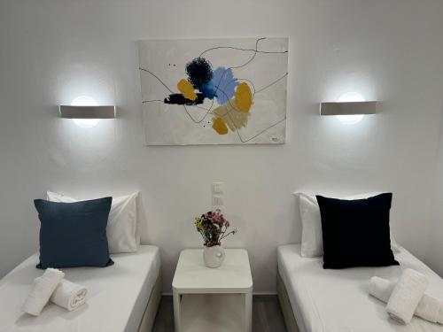 a living room with two beds and a painting on the wall at Central Suites Aegina 3 in Aegina Town