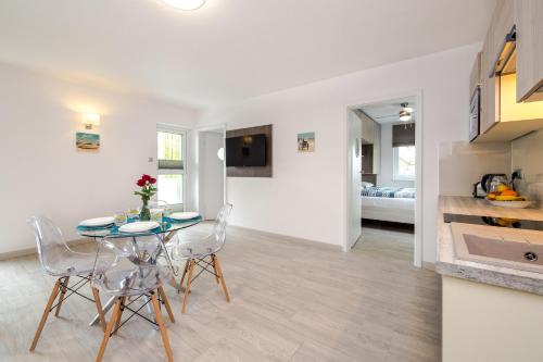 a kitchen and dining room with a table and chairs at Srebrna Wydma Resort in Dąbki