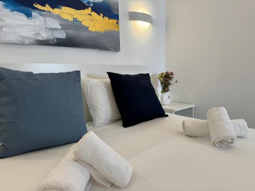 um sofá branco com almofadas pretas e brancas em Central Suites Aegina 3 em Egina