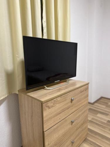 gvero apartment’s في بريليب: يوجد تلفزيون بشاشة مسطحة فوق خزانة خشبية
