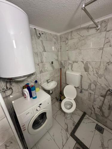 a bathroom with a toilet and a washing machine at gvero apartment’s in Prilep