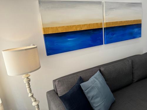 a living room with a couch and a painting on the wall at Central Suites Aegina 3 in Aegina Town
