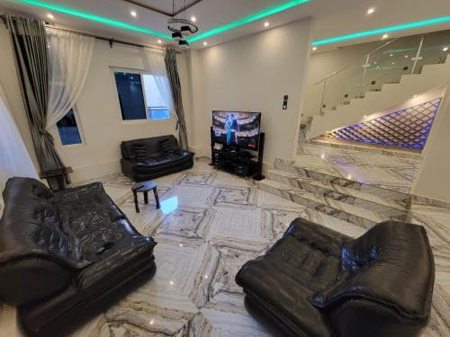 ein Wohnzimmer mit einem Sofa und einem TV in der Unterkunft Villa de Sarah in Lomé