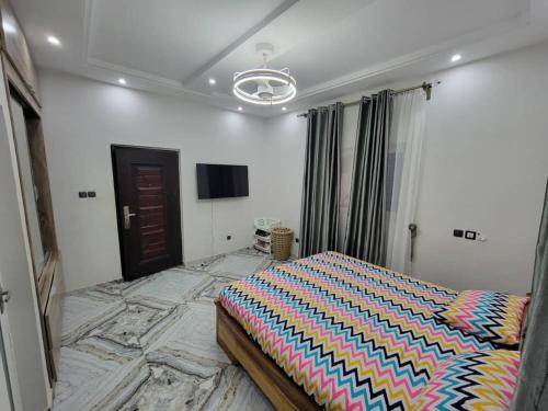 1 dormitorio con 1 cama con un edredón colorido en Villa de Sarah en Lomé