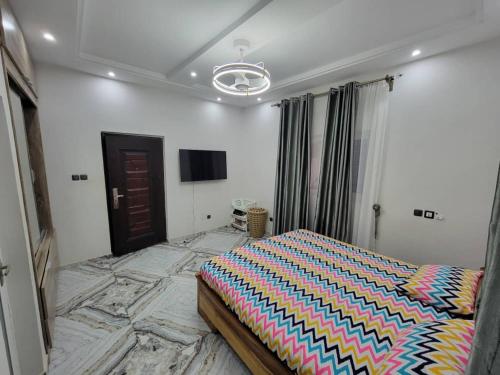 a bedroom with a bed with a colorful comforter at Villa de Sarah in Lomé