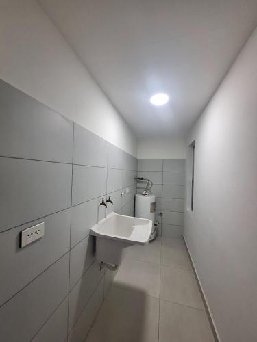 a white bathroom with a sink in the wall at Depar land tower in Tarija