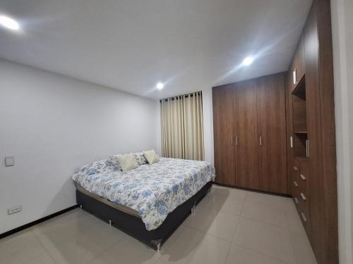 a bedroom with a bed and a wooden cabinet at Depar land tower in Tarija