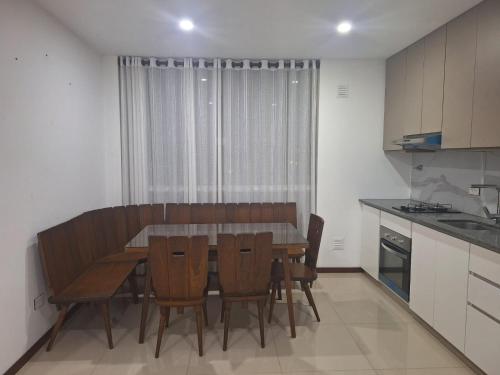 a kitchen with a dining room table and chairs at Depar land tower in Tarija