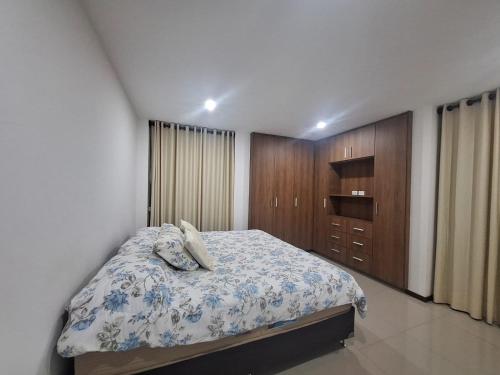 1 dormitorio con 1 cama y armarios de madera en Depar land tower, en Tarija