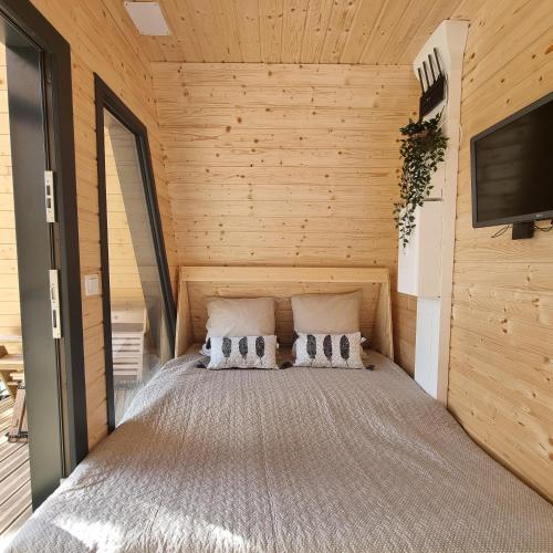 une chambre avec un lit dans un mur en bois dans l'établissement Le tipi Cathare hébergement insolite Carcassonne, à Alairac