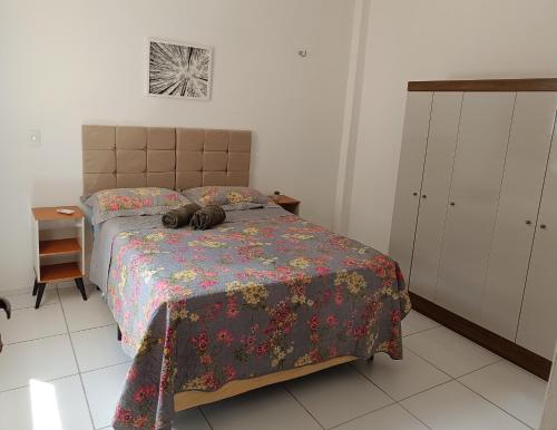 um quarto com uma cama com colcha floral em Ap 101 Aconchegante e Moderno com 3 quartos, sendo 1 suíte em Teresina