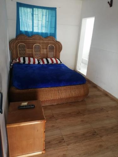 1 dormitorio con 1 cama grande con manta azul en Rayito de sol, en Nocaima