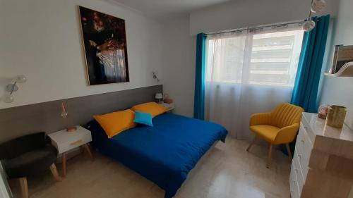 - une petite chambre avec un lit bleu et une chaise dans l'établissement Appartement raffiné Cannes, à Cannes